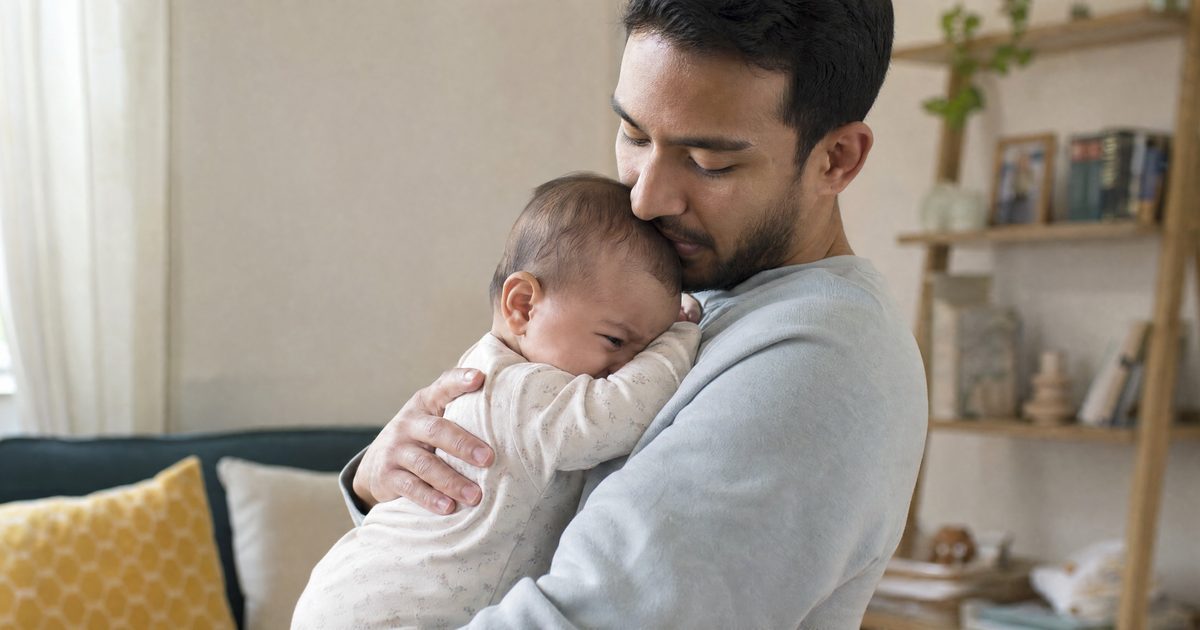 Father gently carrying his fussy baby against his chest