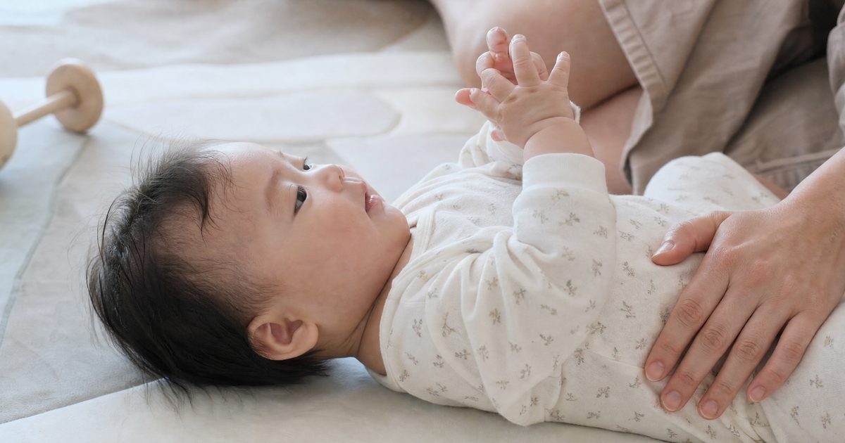 Baby on a play mat, fascinated by its own hands