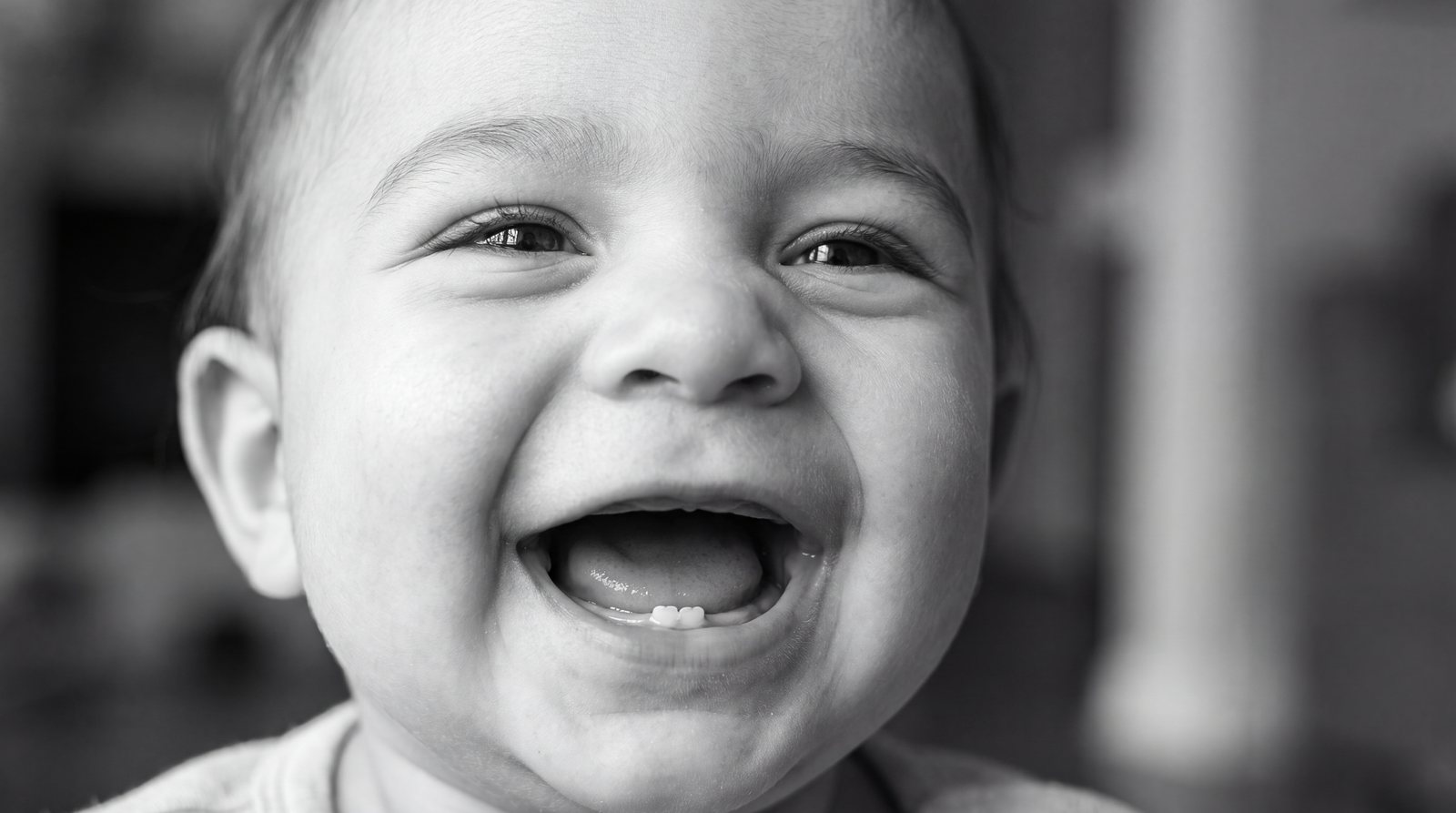 Laughing baby with two first little teeth